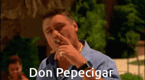 a man in a blue shirt is smoking a cigar with the words don pepecigar below him