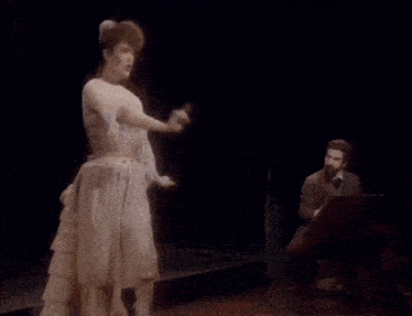 a woman in a white dress is dancing on stage