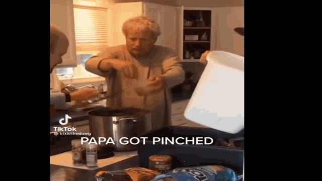 a man is pouring something into a pot in a kitchen while a woman looks on .