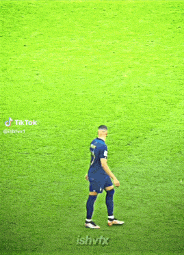 a soccer player with the number 5 on his jersey stands on a field