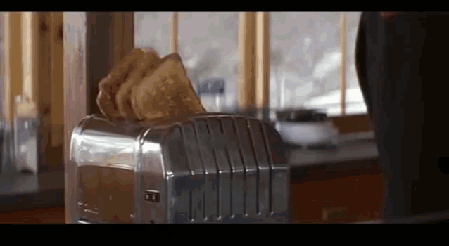 two slices of toast are being toasted in a silver toaster