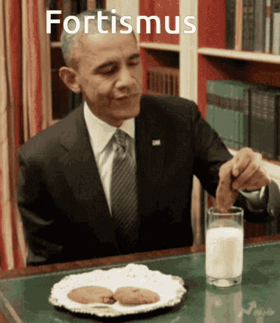a man in a suit is eating cookies and drinking milk