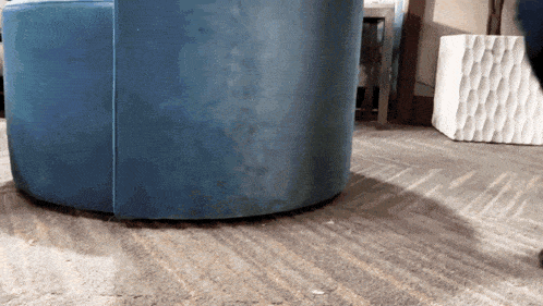 a blue chair is sitting on a carpeted floor next to a white ottoman