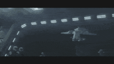 a blurred image of a person standing in a dark room with lights on the ceiling