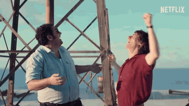 two men are standing next to each other with their arms in the air and a netflix logo behind them