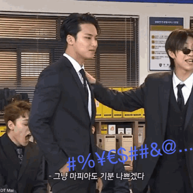 a man in a suit and tie is standing next to another man in a suit