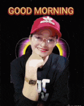 a woman wearing a red adidas hat and glasses is smiling