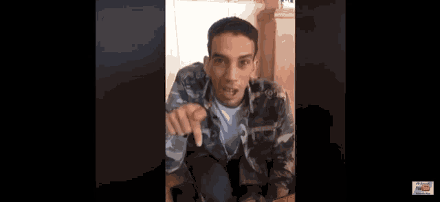 a man in a camo jacket is pointing at something