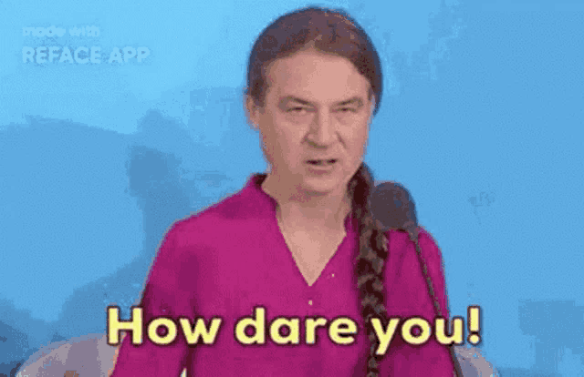 a man in a pink shirt is talking into a microphone and saying `` how dare you '' .