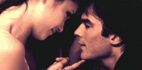 a man and a woman are touching each other 's faces and looking at each other .