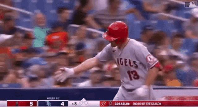 a baseball player with the number 18 on his jersey is running towards home plate .
