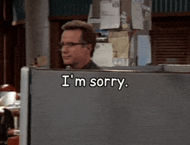 a man behind a cubicle with the words i 'm sorry written on it