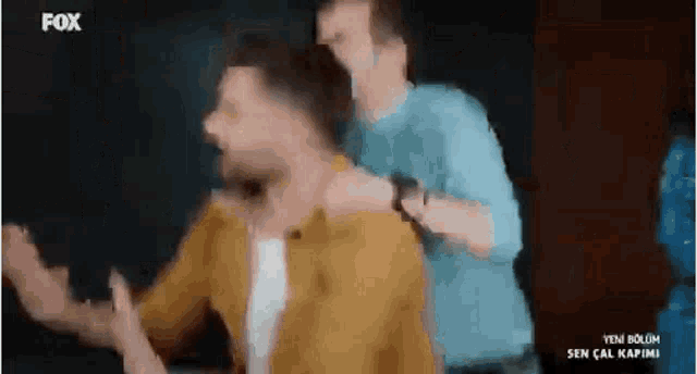 a man in a yellow shirt is being attacked by another man .