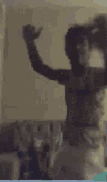 a man is standing in front of a mirror with his hands on his hips .