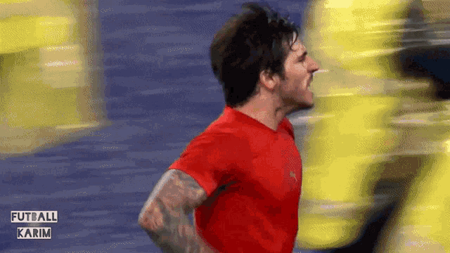 a man in a red shirt with the word futball karim on the bottom right corner