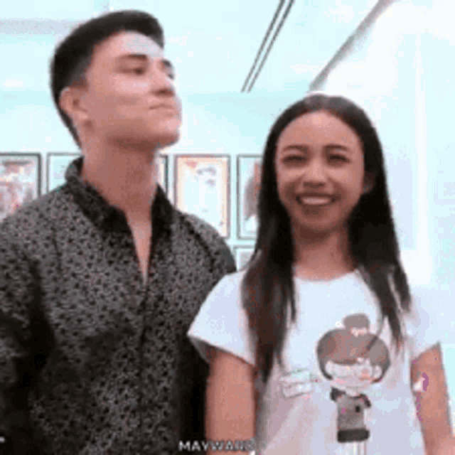 a man and a woman are standing next to each other .