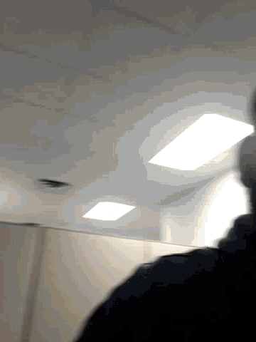 a person is standing in front of a white wall with a few squares on it