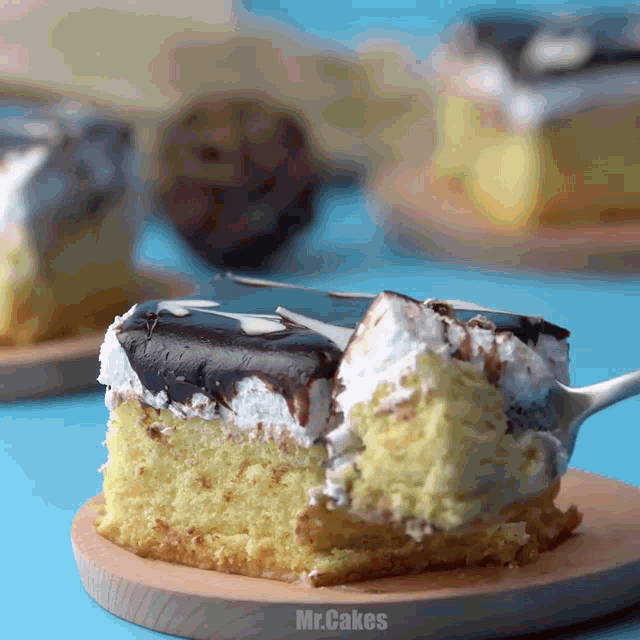 a piece of cake on a wooden cutting board with the words mr.cakes on the bottom right