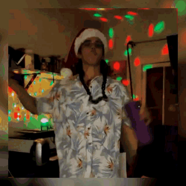 a man wearing a santa hat and hawaiian shirt is dancing