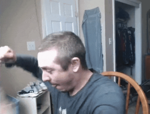 a man in a black shirt is sitting in a chair in front of a closet