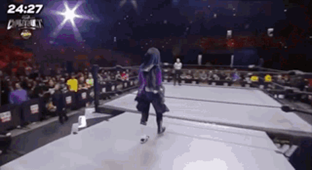 a woman in a hijab is walking on a wrestling ring