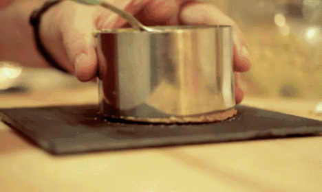 a person is holding a metal container with a spoon on top of it
