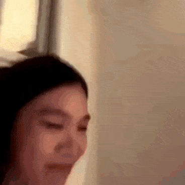 a woman is making a funny face with her eyes closed .