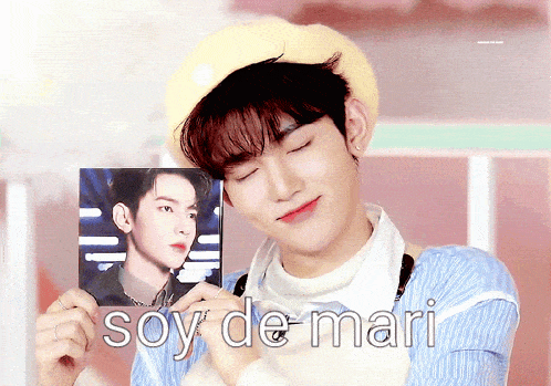 a young man is holding a picture of himself with the words soy de mari written below it