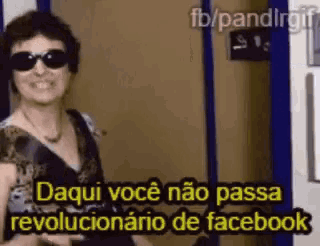 a woman wearing sunglasses is standing in front of a door and says daqui voce não passa revolucionario de facebook .