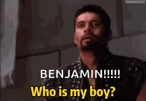 a man with spikes on his shirt is asking who is my boy
