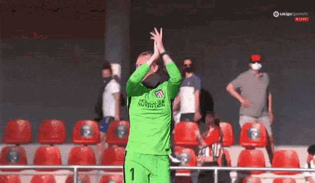 a soccer player wearing a green jersey with the number one on it
