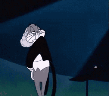 bugs bunny from looney tunes is standing in front of a dark background .