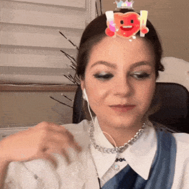 a woman wearing ear buds and a necklace has a heart on her forehead