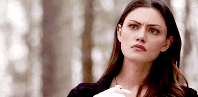 a close up of a woman 's face with a slight smirk on her face