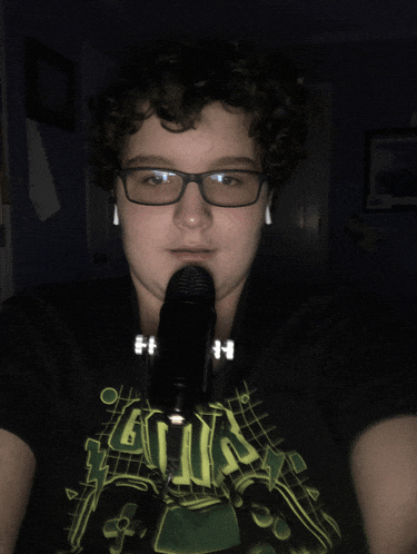 a young boy wearing glasses and a shirt that says ' aliens ' on it