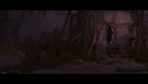 a cliff with trees growing on it and a purple sky in the background