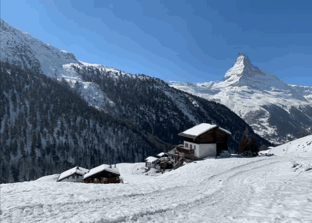a snowy landscape with a mountain in the background and a small house in the foreground