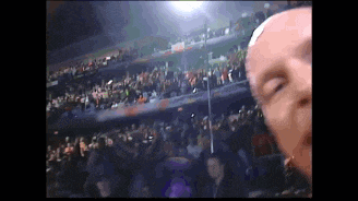 a man is taking a picture of himself in front of a crowd in a stadium .