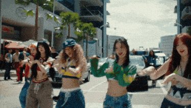 a group of girls are dancing on a street with a sign that says lunch