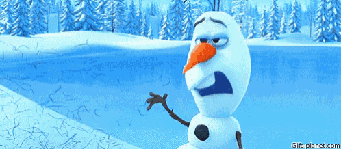 a snowman with a carrot nose is standing in the snow near a body of water