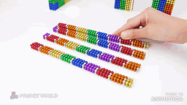 a person is playing with a bunch of colorful magnet beads