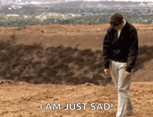 a man walking in the dirt with the words i am just sad written below him