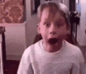 a young boy is making a funny face with his mouth wide open .