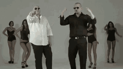 a man and a woman are dancing together in front of a group of women in lingerie .