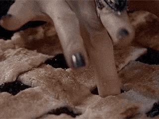 a close up of a person 's fingers on a pie
