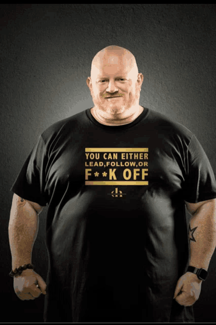 a man is wearing a black shirt that says you can either lead follow or f * k off