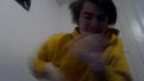 a blurry picture of a man in a yellow sweatshirt