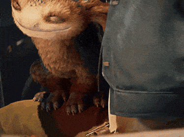 a stuffed animal is sitting on a person 's lap with its eyes closed