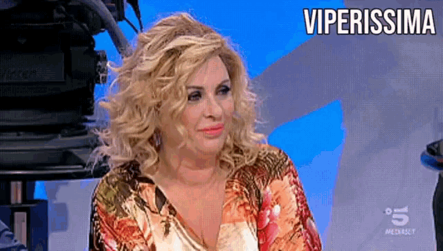 a woman sitting in front of a camera with the word viperissima on the bottom