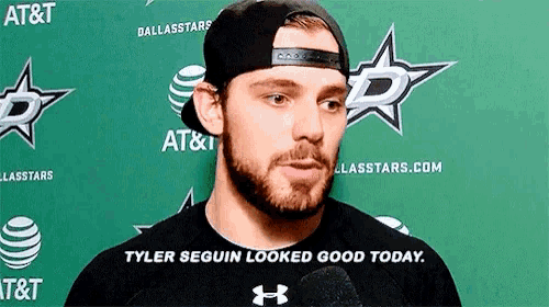 a man with a beard is wearing a hat and a black shirt with the words tyler seguin looked good today on it